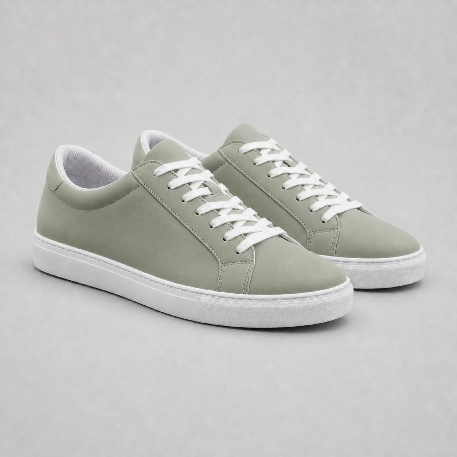 Change the sneakers from white to sage green while preserving every material detail. (After)